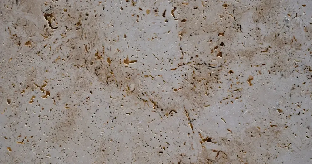 Superfície de travertino bege com cavidades naturais, base para pesquisar o preço do travertino romano por m²